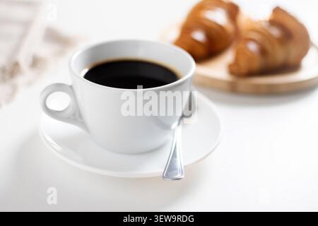 Black Coffee Cup with Croissants on White Table in Cozy Breakfast Setting Stock Photo