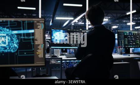Data center engineer reviews artificial intelligence systems and machine learning processes inside a data center. Stock Photo