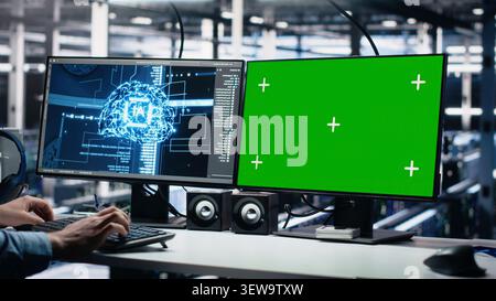 Data center engineer uses green screen PC in a server room to monitor AI diagnostics and neural network performance. Stock Photo