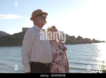 Senior couple enjoying a sunny day by the sea Stock Photo