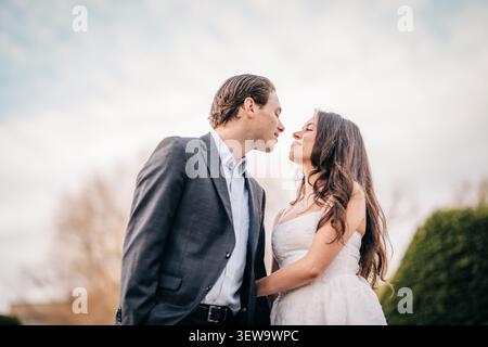Young couple sharing intimate moment outdoors on wedding day Stock Photo