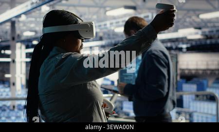 African american IT professional uses a VR headset in a server room to adjust AI systems and improve processing performance. Stock Photo