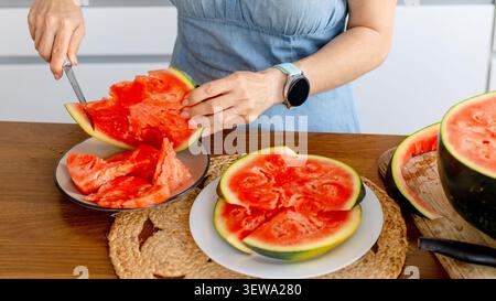 Woman Slicing Juicy Watermelon At Home Close-Up Stock Photo