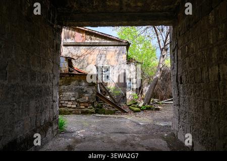 Weathered stone archway frames abandoned building Stock Photo