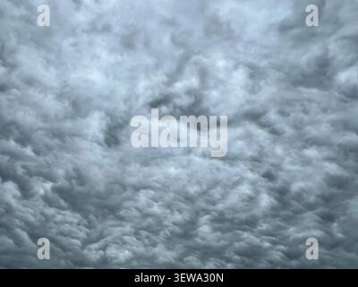 Full frame overcast sky filled with dense layered grey clouds on a cloudy day Stock Photo