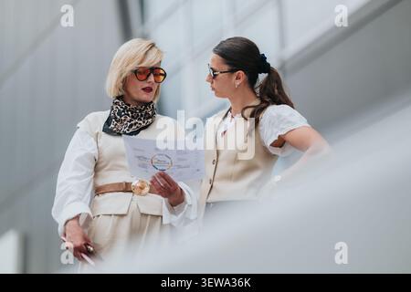 Business colleagues discussing plans over a printed chart during a casual corporate meeting Stock Photo