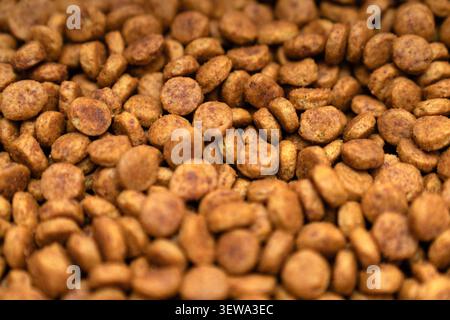 Macro top view of premium dry pet food kibble texture. High protein organic brown pellets for healthy dog and cat nutrition. Stock Photo