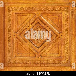 Elaborate wooden panel featuring a carved celtic cross in the center, surrounded by intricate knotwork details Stock Photo