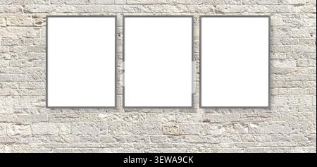 Three empty frames offering copy space on a textured white brick wall background Stock Photo