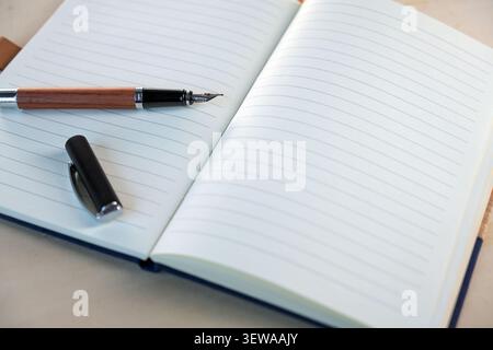 Open notebook with blank lined paper and a fountain pen, concept image for handwriting, diary, notes, and creative writing, copy space, selected focus Stock Photo