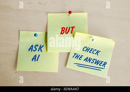 Yellow sticky notes with text Ask AI but Check the Answer, attached on a wooden board, concept to combat gullibility toward artificial intelligence s Stock Photo