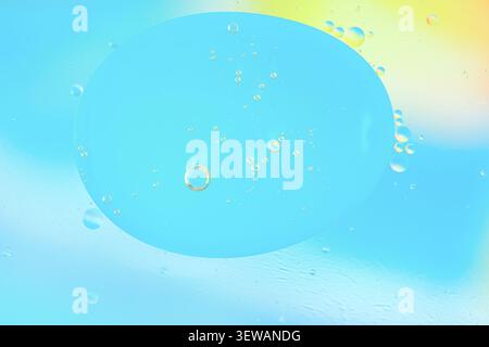 Blue macro bubbles on a soft cyan background, smooth translucent droplet, airy abstract composition, copy space present. Stock Photo