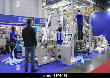 Bangkok, Thailand - June 17, 2026: Technicians operating and demonstrating SPL Machinery blown film extrusion machine with touchscreen control at Manu Stock Photo