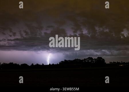 Branched lightning strike under low dramatic clouds Stock Photo