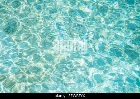 Underwater caustics create intricate patterns of light and texture on the surface of clear sea water. Sunlight filters through, forming beautiful refl Stock Photo