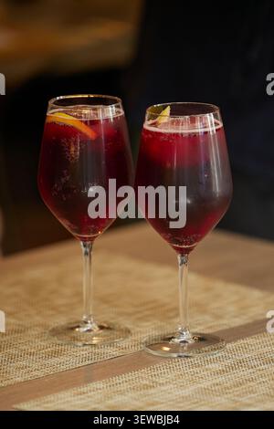 Cold spanish sangria in two transparent glasses on the table in the restaurant. Stock Photo
