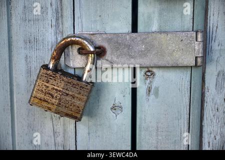 Rusty old padlock on blue wooden doors Stock Photo