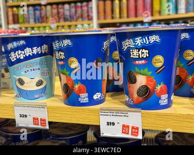 Khimki, Russia - June 25, 2026: Ice cream cups with Oreo cookies and strawberry flavor displayed on wooden shelf in grocery store Stock Photo