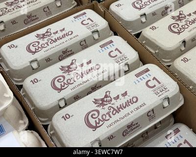 Khimki, Russia - June 25, 2026: Cardboard egg cartons labeled with Russian text and a chicken logo stacked in a grocery store display Stock Photo