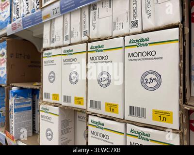 Khimki, Russia - June 25, 2026: Milk cartons on supermarket shelf with labels in Russian, various brands, and nutritional information visible Stock Photo