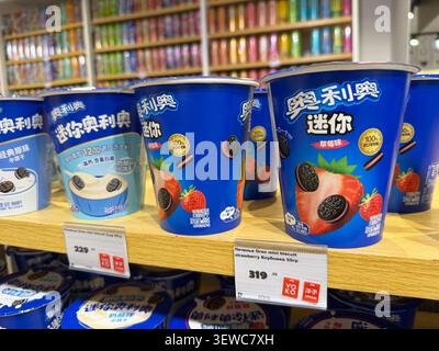 Khimki, Russia - June 25, 2026: Blue yogurt cups with strawberry and Oreo flavors displayed on a wooden shelf in a grocery store Stock Photo