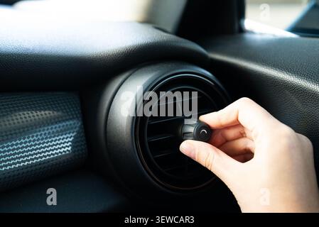 Close up of hand wiping black car interior with microfiber cloth Stock Photo