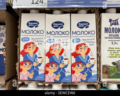 Khimki, Russia - June 25, 2026: Milk cartons with cartoon character design in a grocery store, featuring 2.5 fat content and Russian text labels Stock Photo