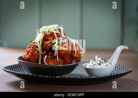 Delicious Golden Fritters With Creamy Dipping Sauce Served on a Stylish Plate Stock Photo