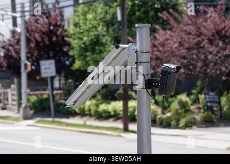 Fort Lee, NJ, USA - May 17, 2026: Solar-powered Flock Safety AI license plate reader camera monitors street traffic in Fort Lee, New Jersey. Stock Photo