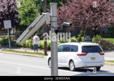 Fort Lee, NJ, USA - May 17, 2026: Solar-powered Flock Safety AI license plate reader camera monitors street traffic in Fort Lee, New Jersey. Stock Photo