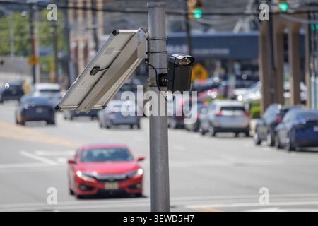 Fort Lee, NJ, USA - May 17, 2026: Solar-powered Flock Safety AI license plate reader camera monitors street traffic in Fort Lee, New Jersey. Stock Photo
