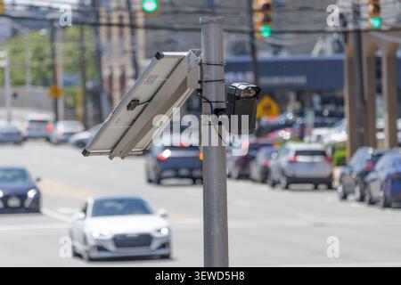 Fort Lee, NJ, USA - May 17, 2026: Solar-powered Flock Safety AI license plate reader camera monitors street traffic in Fort Lee, New Jersey. Stock Photo