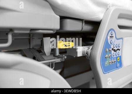 Hospital bed CPR release lever in a modern medical facility. Essential safety feature for emergency care and rapid life support response. Stock Photo