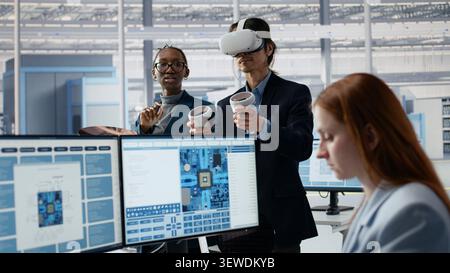 Microchip research facility experts in office using VR headset to examine semiconductor substrates. Employees using virtual reality simulation to inspect silicon wafers, camera A Stock Photo