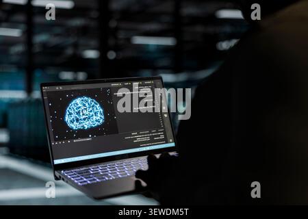Computer scientist works with a computer workstation in a server hub to support artificial intelligence systems. Stock Photo