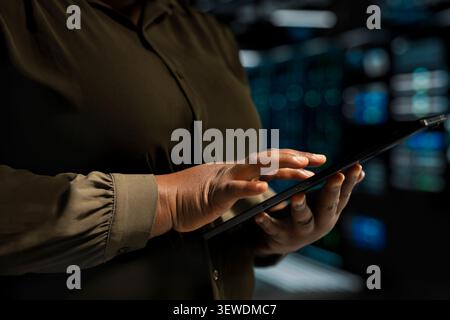 IT expert provides technical support from a data center using a headset while troubleshooting client server issues. Stock Photo