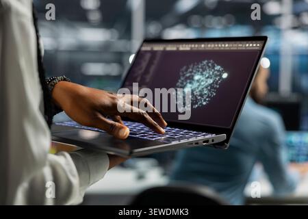 Computer scientist uses an AI language model assistant in a server hub to handle infrastructure maintenance. Stock Photo