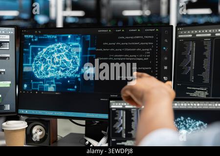 Computer scientist uses a desktop computer in a data center to manage AI systems and optimize server infrastructure. Stock Photo