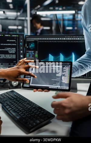Data center team works with digital tablet in a data center to support data processing, analytics, and storage infrastructure. Stock Photo