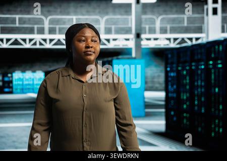 System administrator uses a digital device in a data center to monitor equipment, manage workflows, and support reliable infrastructure. Stock Photo