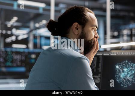 Data scientist uses a desktop computer in a data center to manage AI visualization and optimize server infrastructure. Stock Photo