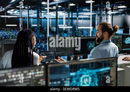 Man works with a computer workstation in a server room to support artificial intelligence systems. Stock Photo