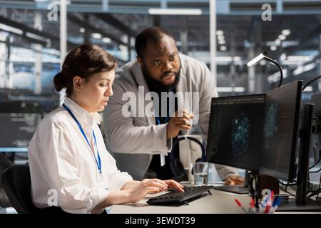 Data center colleagues collaborate on coding and AI automation scripts while reviewing server infrastructure together. Stock Photo