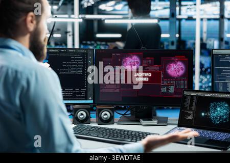 Software developer works with a computer workstation in a server room to support artificial intelligence systems. Stock Photo