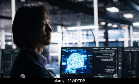 Software developer works on a computer to monitor AI systems, neural networks and server infrastructure. Stock Photo