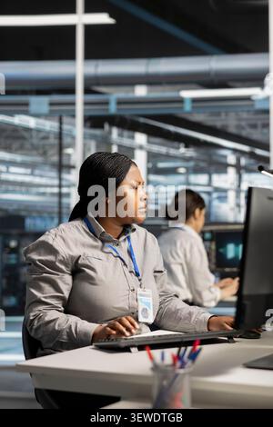 Software developer uses a computer to run diagnostics, update servers and check infrastructure performance. Stock Photo