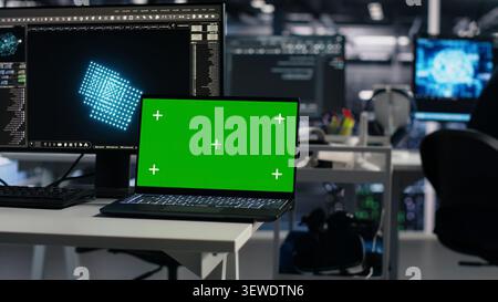 Software developer uses a green screen laptop to manage AI systems, machine learning workflows and server performance. Stock Photo