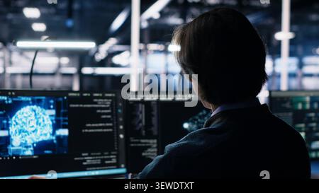 Data center engineer works on a computer to monitor AI systems, neural networks and server infrastructure. Stock Photo