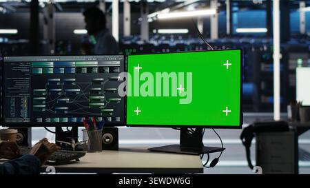 Engineer uses a green screen computer in a server farm to categorize unstructured data with node tree systems. Stock Photo