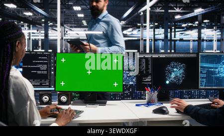 IT colleagues collaborate in a data center while reviewing AI diagnostics and infrastructure performance. Stock Photo